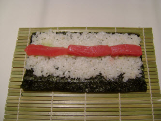 Spread a row of tuna across the rice...