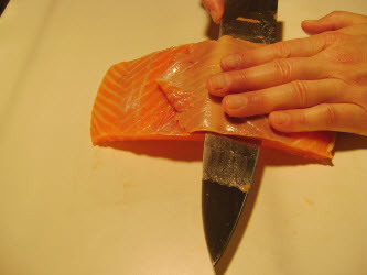 Trimming off outer brown part from premium scottish salmon